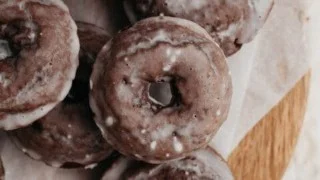 Freshly baked chocolate cake doughnuts on a cooling rack