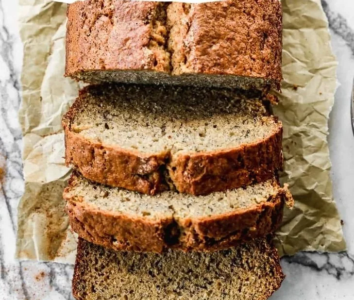 Freshly baked banana bread loaf on a wooden cutting board