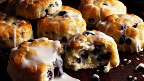 A plate of warm Bo Berry Biscuits with a berry glaze on top.