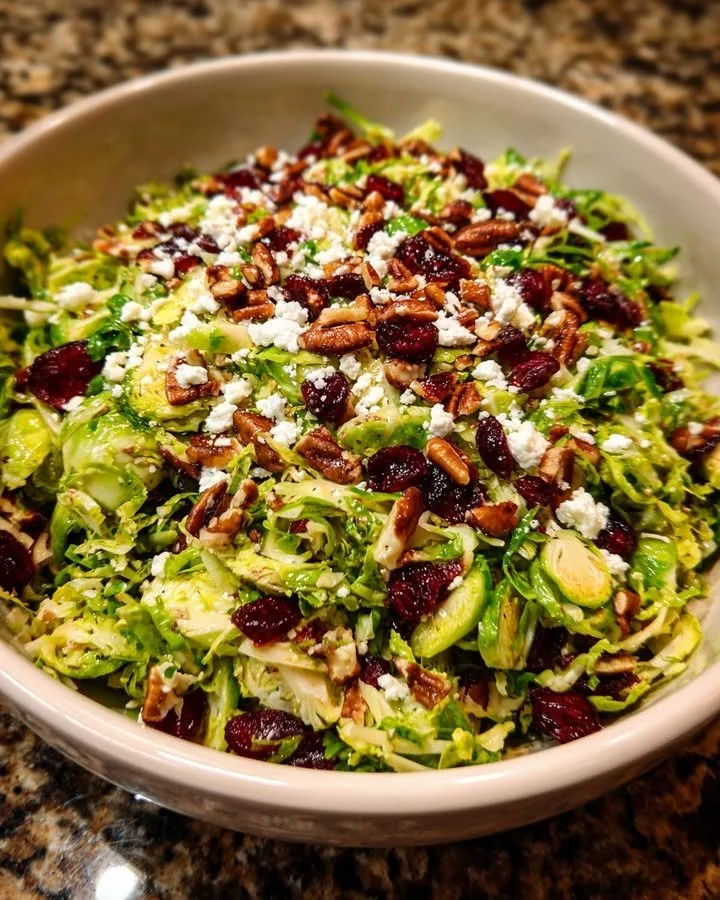 Brussels Sprouts Salad topped with cranberries, pecans, and feta cheese