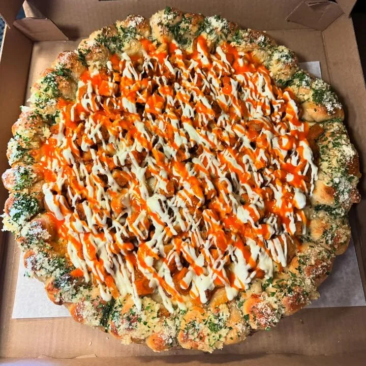 Delicious Buffalo Chicken Pizza with a Garlic Knot Crust on a wooden board