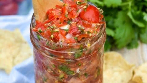 Homemade cherry tomato salsa served in a bowl with fresh ingredients