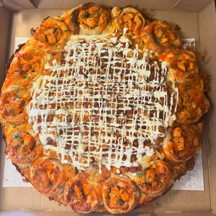 Delicious Chicken-Bacon-Ranch Pizza topped with chicken, bacon, and ranch dressing.