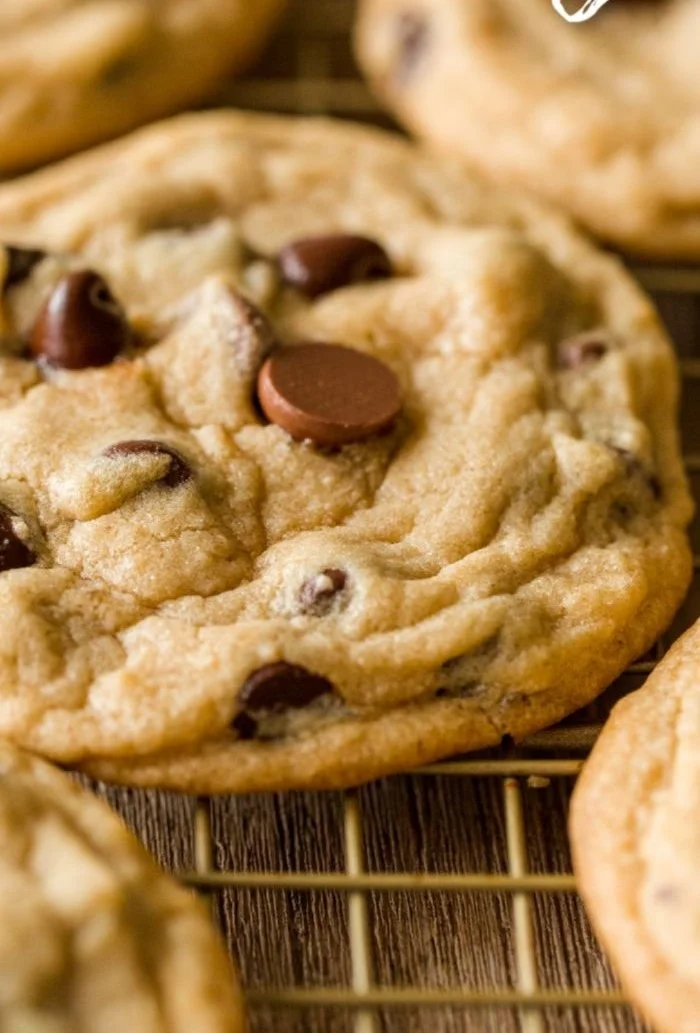 Freshly baked chocolate chip cookies on a cooling rack.