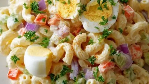 Bowl of classic macaroni salad with vegetables and dressing