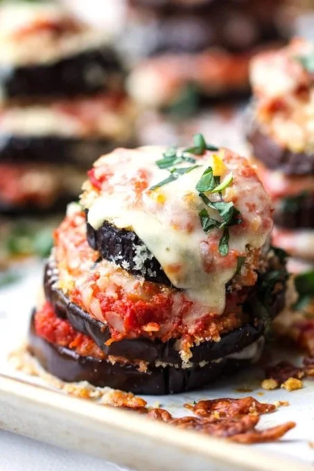 Delicious Eggplant Parmesan Stacks served on a plate with rich marinara sauce.