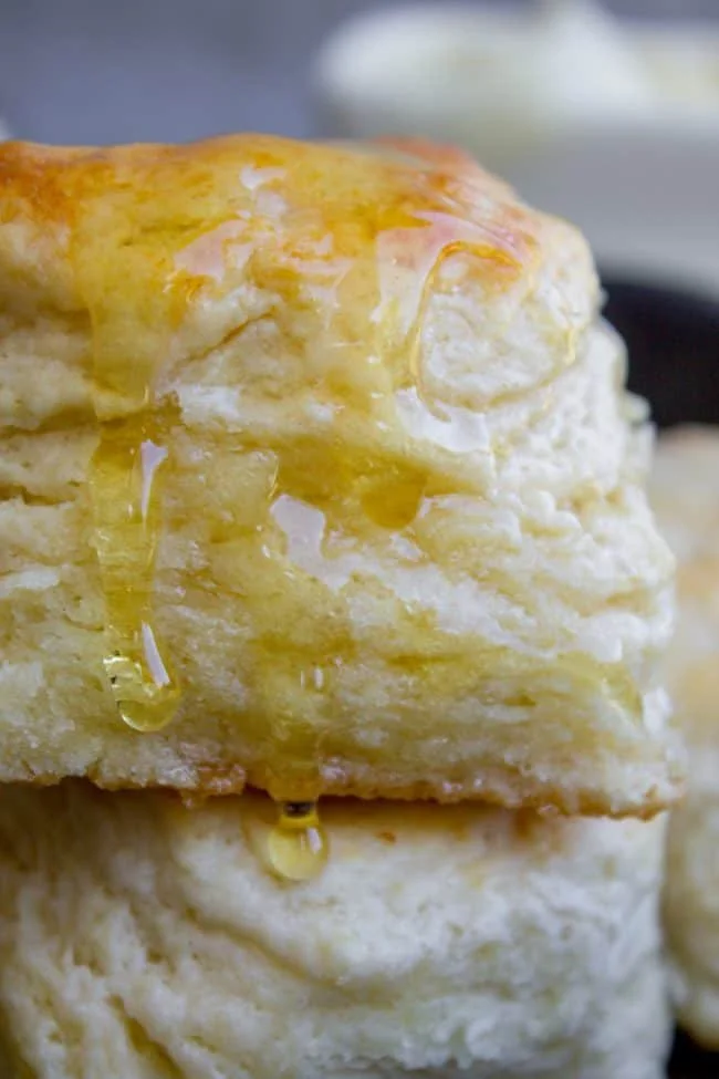 Flaky buttermilk biscuits served with butter on a wooden table