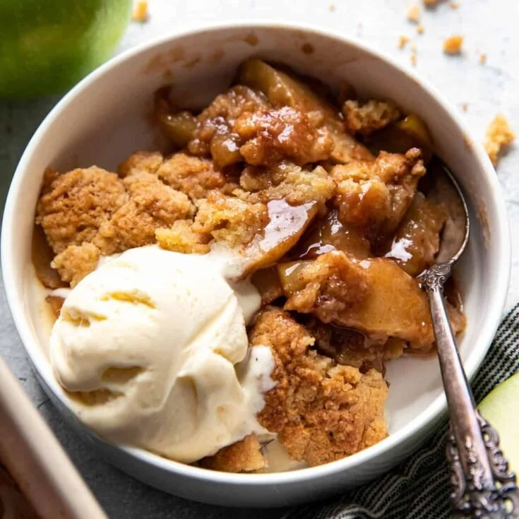 Delicious homemade apple cobbler served in a rustic dish with a scoop of vanilla ice cream.