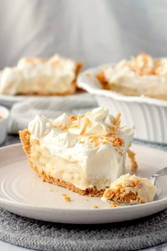 Delicious homemade coconut cream pie with whipped cream topping and toasted coconut flakes.