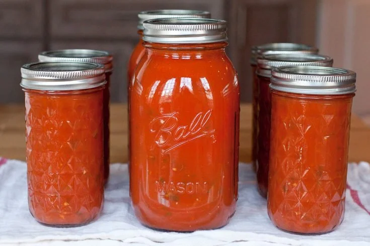 A bowl of homemade marinara sauce with fresh basil and tomatoes