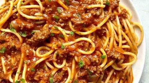 Bowl of homemade spaghetti sauce with fresh herbs and tomatoes