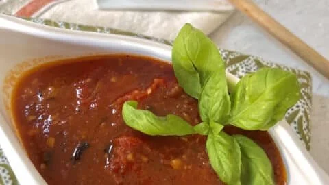 Fresh homemade tomato sauce in a pot with herbs and ingredients