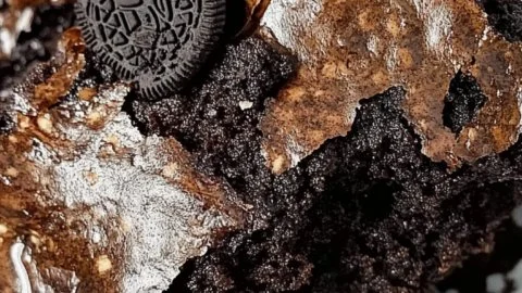 Deliciously layered Oreo Dump Cake with cream and cookie crumbles.