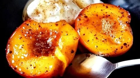 Delicious pan-fried peaches served with a drizzle of honey and mint leaves