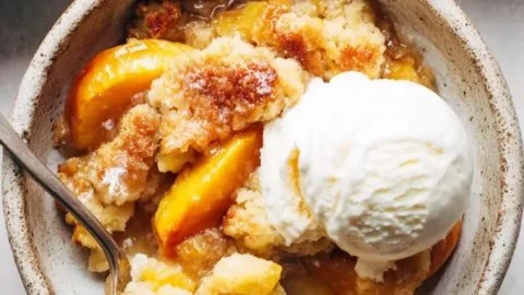 Freshly baked peach cobbler served in a dish