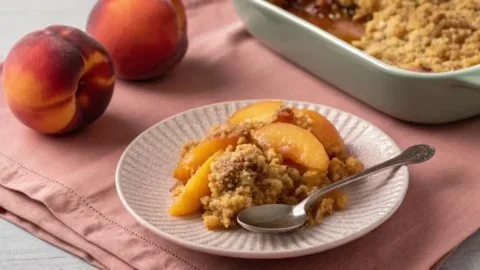 Freshly baked Peach Crisp topped with golden oats and crumbles