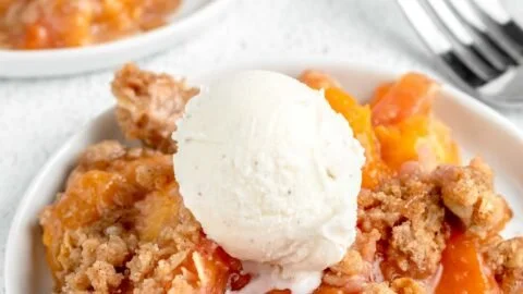 Baked peach crisp topped with crunchy oats and brown sugar