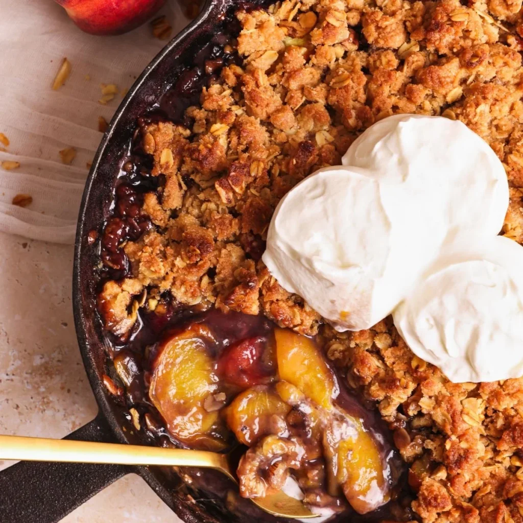 Delicious homemade Peach Crumble served warm with a scoop of ice cream
