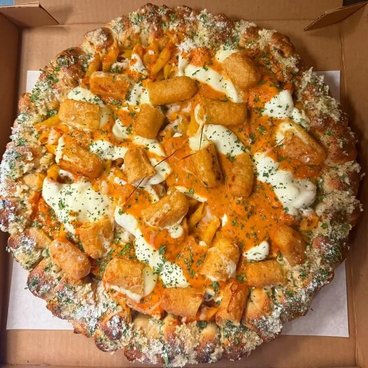 Penne Vodka & Mozzarella Stick Round Sicilian Pizza sliced on a plate