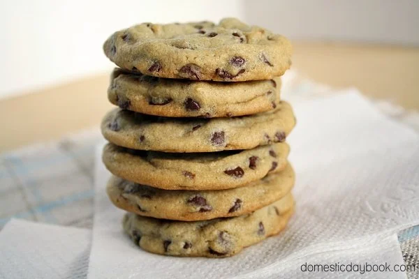 Freshly baked soft and chewy chocolate chip cookies on a cooling rack.