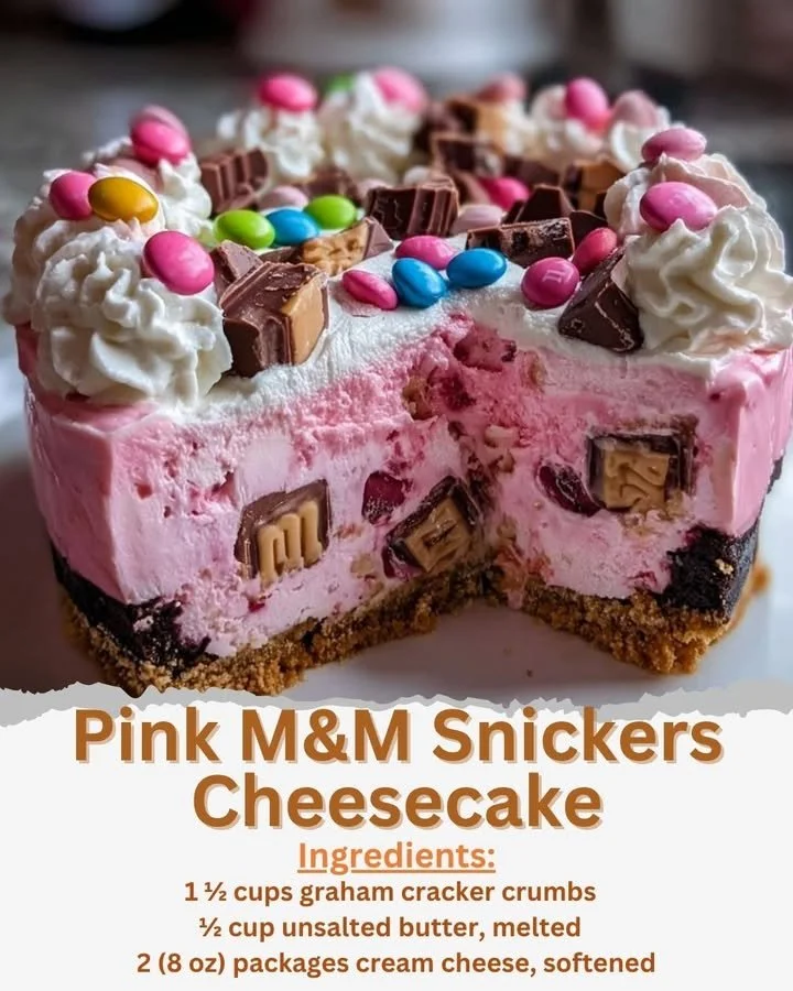 Pink M&M Snickers Cheesecake topped with colorful M&Ms and Snickers pieces