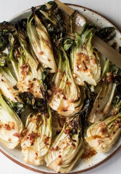 Roasted bok choy served on a plate with a garnish