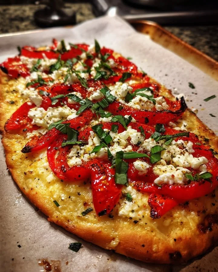 Roasted red pepper flatbread topped with feta cheese and fresh basil