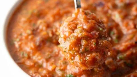 Delicious roasted tomato salsa served in a bowl with tortilla chips