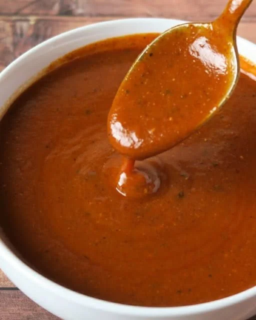 Homemade smoky red enchilada sauce in a bowl with spices