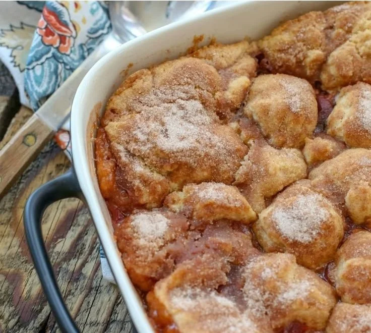 Delicious Southern peach cobbler served warm with a scoop of vanilla ice cream.