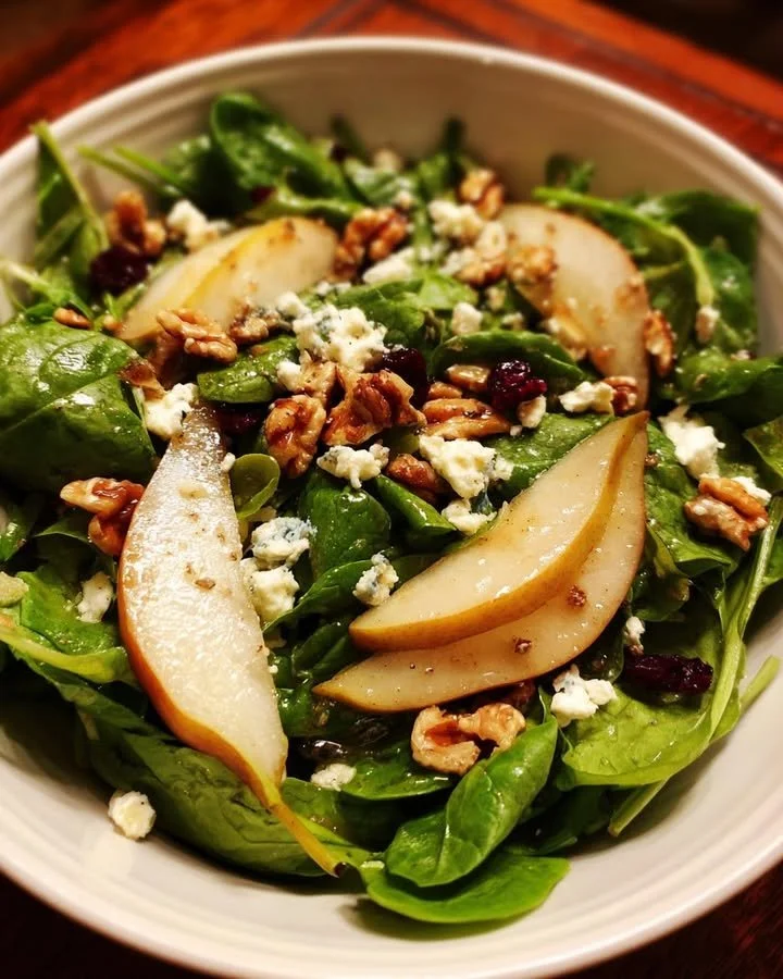 Spinach salad with arugula, goat cheese, pears, and balsamic dressing