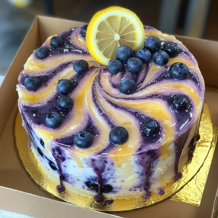 Swirled blueberry lemon cake topped with fresh blueberries and lemon zest