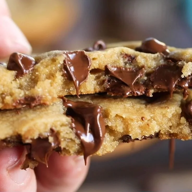 A plate of homemade chocolate chip cookies with melting chocolate chips.