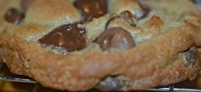 Thick chewy chocolate chip cookies stacked on a plate.