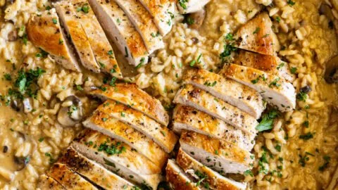 Delicious Chicken Mushroom Risotto topped with fresh herbs and parmesan cheese.