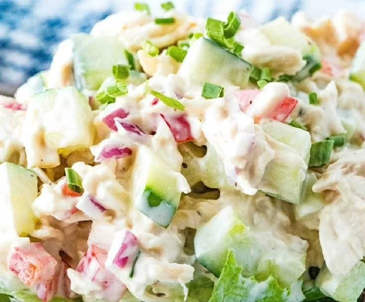 Delicious chicken salad served in a bowl with fresh vegetables and dressing