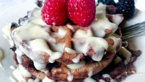 Delicious keto cinnamon roll waffles topped with cream cheese icing