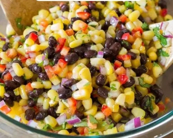 Corn and black bean salad with fresh vegetables in a bowl