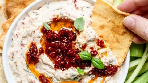 Creamy sun-dried tomato dip served with crackers and fresh vegetables