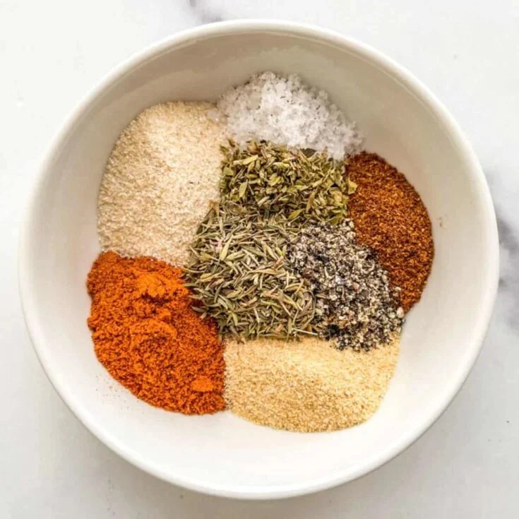 Bowl of Creole seasoning with spices on a wooden table