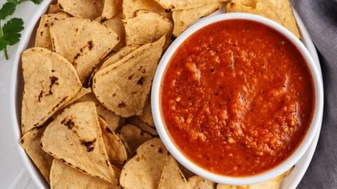 Bowl of easy red salsa garnished with cilantro and lime