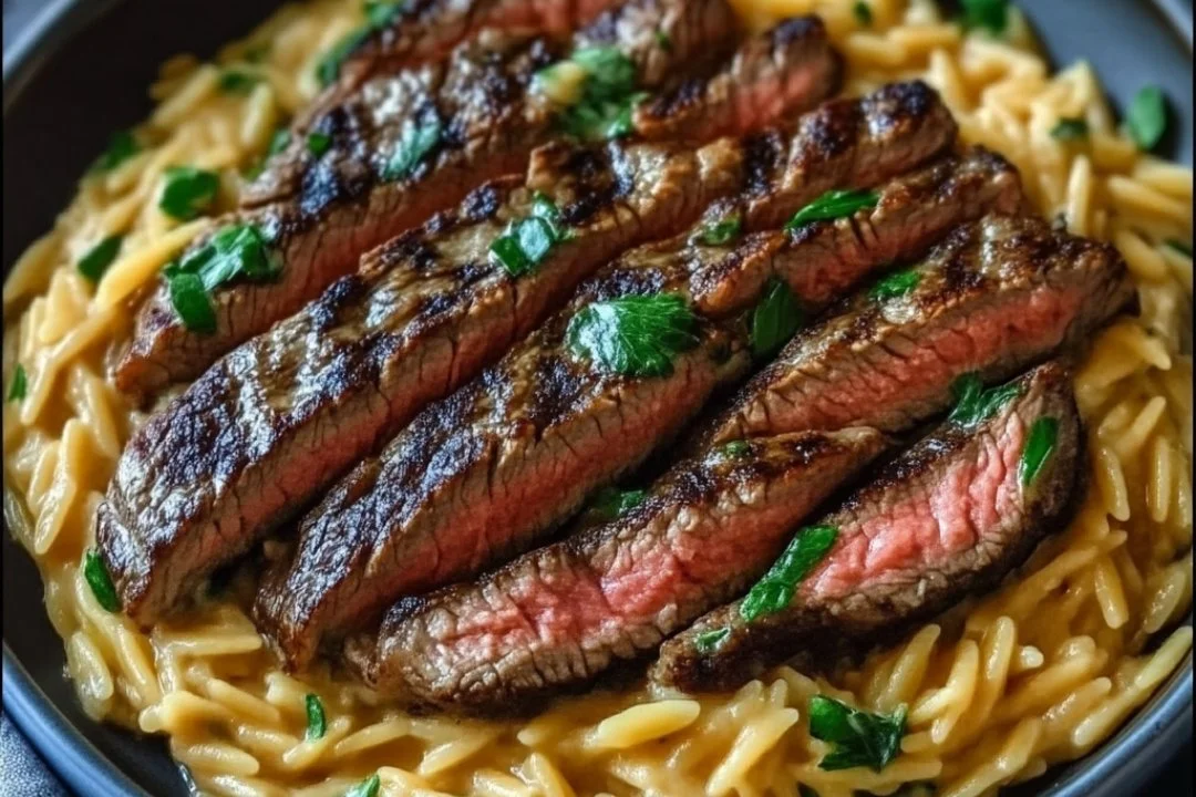 Grilled flank steak served with creamy orzo on a rustic plate