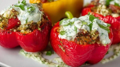 Greek stuffed peppers with tzatziki sauce served on a plate