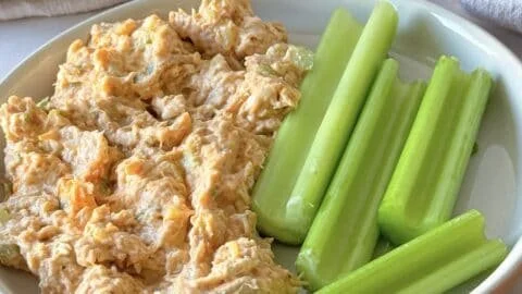 High protein buffalo chicken salad in a bowl with fresh greens and dressing