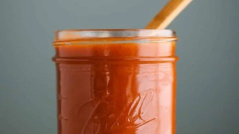 Homemade enchilada sauce in a bowl with spices and tomatoes