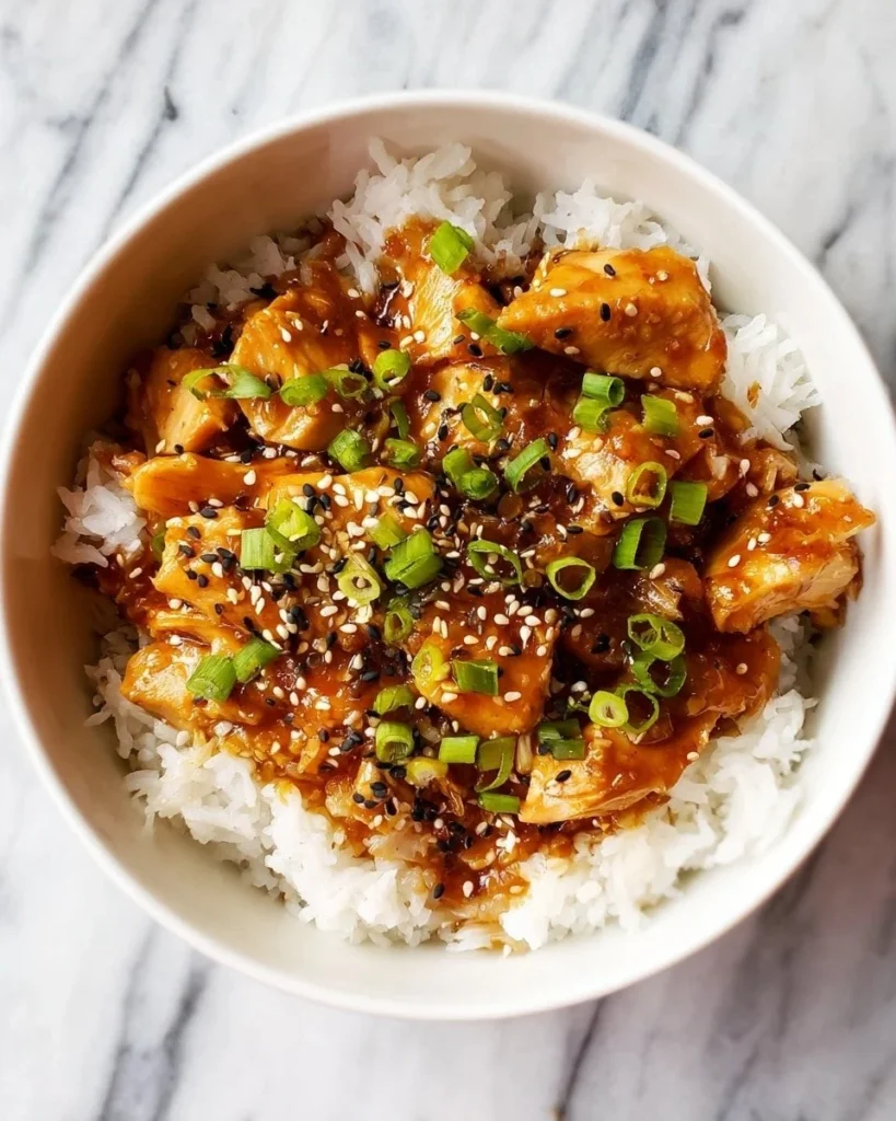 Honey garlic chicken thighs in a slow cooker with fresh herbs and spices