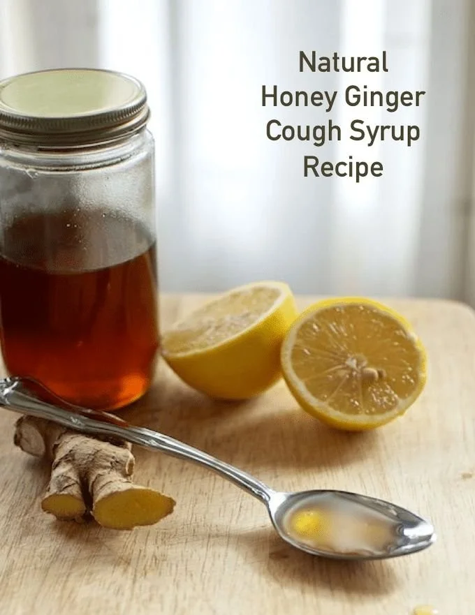 A bottle of Honey Ginger Cough Syrup with a wooden spoon and ginger root.