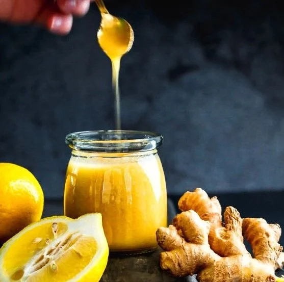 Honey ginger syrup with lemon in a glass jar on a wooden table