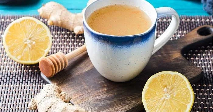 A cup of honey lemon ginger tea with fresh ingredients