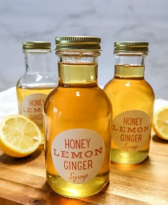 Honey Lemon Ginger Syrup in a glass jar with fresh ingredients